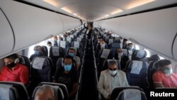 Para penumpang pesawat mengenakan masker menyusul merebaknya pandemi virus corona di Bandara International Kairo, di Kairo, Mesir, 18 Juni 2020. (Foto: Reuters)