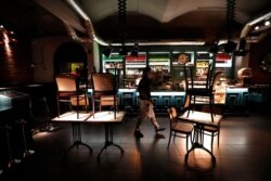 A staff member walks inside a closed bar in Prague, Czech Republic, Oct. 9, 2020. The Czech government has responded to record-high numbers of coronavirus infections by imposing further restrictive measures to contain the surge.