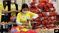 A volunteer packs onions in the warehouse of the Alameda County Community Food Bank in Oakland, Calif., on Nov. 5, 2021. 