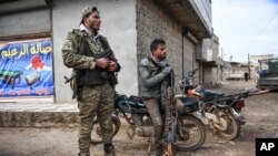 Para pemberontak Suriah duduk di luar Idlib, Suriah, 15 Februai 2020. (AP Photo)