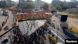 People form a "V" for "vote" in red and yellow, colors of the Catalan flag, to mark "Diada," central Barcelona, Sept. 11, 2014.