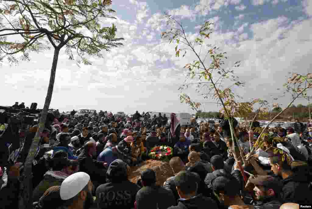 Bedouins sit near the gravesite of Salah Abu Latif during his funeral in Rahat in southern Israel, Dec. 25, 2013. 