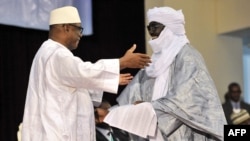 Mali's President Ibrahim Boubacar Keita (L) embraces Tuareg rebel coalition representative Mahamadou Djery Maiga on June 20, 2015, in Bamako.