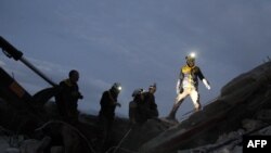 FILE - Members of the Syrian Civil Defence, also known as the White Helmets, search for survivors following an airstrike on the flashpoint town of Maaret al-Numan in Syria's northwestern Idlib governorate, Dec. 30, 2019. 