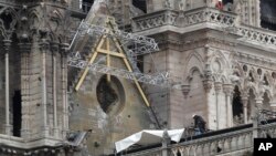 Workers install tarps at Notre Dame cathedral in Paris, France, April 23, 2019. 