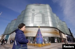 A woman walks past an Intime Lotte Department Store in downtown Beijing, China Jan. 10, 2017.