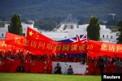 亲中国的支持者在澳大利亚堪培拉议会大厦前举旗帜欢迎中国总理李克强到访澳大利亚。（2017年3月23日）
