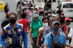 រូបឯកសារ៖ អ្នកបើករថយន្តក្រុងដែលបានបាត់បង់ការងារឈរតម្រង់ជួរដើម្បីទទួលជំនួយ បន្ទាប់ពីរដ្ឋាភិបាលបានចាត់វិធានការបិទសកម្មភាពក្នុងប្រទេស នៅទីក្រុង Quezon ប្រទេសហ្វីលីពីន កាលពីថ្ងៃទី៧ ខែសីហា ឆ្នាំ២០២០។