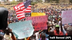 Supporters of Kenya's Opposition party Coalition for Reforms and Democracy (CORD), hold up banners and the US flag ahead of a CORD rally at Uhuru Park, Nairobi, Kenya, Wednesday, Sept. 23, 2015, in solidarity with striking teachers.
