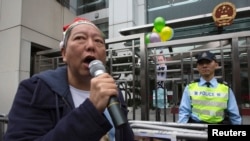 FILE - Pro-democracy lawmaker Lee Cheuk-yan speaks after releasing balloons with caricatures of jailed Chinese Nobel Peace Prize laureate Liu Xiaobo during a protest outside the Chinese liaison office in Hong Kong.