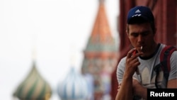 A man smokes a cigarette at Moscow's Red Square June 1, 2013. Russia has banned smoking at schools and universities, museums, sports facilities, hospitals and on public transportation. (FILE PHOTO)
