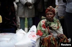 አንድ ሴት ከኢትዮጵያ ቀይ መስቀል ማኅበር ምግብ ለመቀበል ተራ እየጠበቁ /ፋይል ፎቶ - ሮይተርስ/