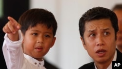 Sons of Prince Norodom Ranariddh, Prince Chakravuth, right, and Prince Ranavong, left, who is the last child of Ouk Phalla, attend the cremation ceremony, in Phnom Penh, Cambodia, Wednesday, June 20, 2018. (AP Photo/Heng Sinith)