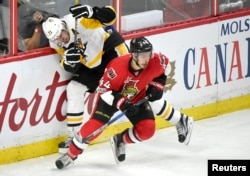 캐나다 오타와에서 열린 북미프로하키 오타와 세너터스와 피츠버그 펭귄스의 경기에서 세너터스 장 가브리엘 파기 선수가 펭귄스 에브게니 말킨 선수를 보디체크로 저지했다.