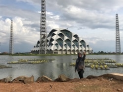 Seorang wanita berfoto di Embung Gedebage, Kota Bandung, yang berdampingan dengan Masjid Raya Jawa Barat. Bersama dua proyek lainnya, embung ini dibuat untuk kendalilan air di Bandung Raya.