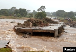 A man looks at a washed away bridge along Umvumvu river following Cyclone Idai in Chimanimani, Zimbabwe, March 18, 2019.