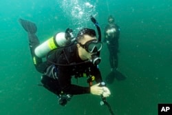 FILE - Justin Miyano, left, vessel operations coordinator, and Kimberly Roberson, research coordinator for Gray's Reef National Marine Sanctuary, make a safety stop while scuba diving at the sanctuary Monday, Oct. 28, 2019, off the coast of Savannah, Ga. (AP Photo/David J. Phillip)
