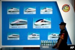 រូបឯកសារ៖ បុគ្គលិក​សន្តិសុខ​ម្នាក់​ដើរក្បែរ​ផ្ទាំង​បង្ហាញ​ពី​គំរូ​រថភ្លើង​ល្បឿន​លឿន​របស់​ចិន នៅ​មុន​កិច្ច​ប្រជុំ​វេទិកា​សហប្រតិបត្តិការ​ចិន-អាហ្វ្រិក​នៅ​រដ្ឋធានី​ប៉េកាំង​របស់​ចិន​ កាល​ពី​ថ្ងៃ​ទី​៣០ ខែ​សីហា ឆ្នាំ​២០១៨។