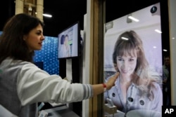 Chloe Szulzinger demonstrates on CareOS, an operating system that connects multiple devices in the bathroom, during CES Unveiled at CES International Sunday, Jan. 7, 2018, in Las Vegas. (AP Photo/Jae C. Hong)