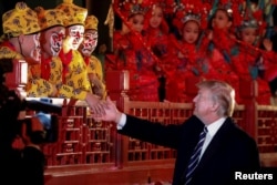 President Donald Trump shakes hands with opera performers at the Forbidden City in Beijing, China, Nov. 8, 2017.