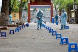 បុគ្គលិក​សុខាភិបាល​បាញ់​ថ្នាំ​សម្លាប់​មេរោគ ដែល​ជា​វិធានការ​ទប់ស្កាត់​ការ​រីករាលដាល​នៃ​ជំងឺ​កូវីដ១៩ នៅ​ក្នុង​ក្រុង​ហាណូយ ប្រទេស​វៀតណាម កាលពី​ថ្ងៃទី៣១ ខែមីនា ឆ្នាំ២០២០។