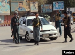 Afghan policemen keep watch in the downtown of Kunduz city, Oct. 3, 2016.