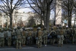 Personel militer siaga di sepanjang Pennsylvania Avenue saat iring-iringan mobil Presiden terpilih AS Joe Biden tiba di Capitol AS, di Washington, AS, 20 Januari 2021. (REUTERS / Tom Brenner)
