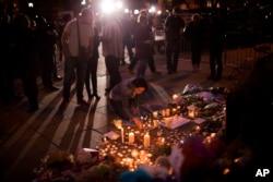 A woman lights candles after a vigil in Albert Square, Manchester, England, May 23, 2017.