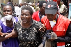 FILE - Red Cross staff console a woman in Nairobi after she viewed the body of a relative killed in al-Shabab's April 2 attack at Garissa University College in northeastern Kenya.