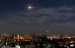 In this photo released by the Syrian official news agency SANA, shows missiles flying into the sky near international airport, in Damascus, Syria, Jan. 21, 2019
