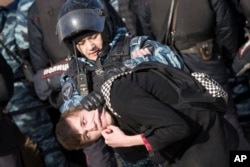 Police detain a protester in downtown Moscow, Russia, Sunday, March 26, 2017.