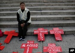 A woman waits for a protest to start in Mexico City, Nov. 25, 2016.