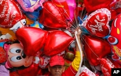 A vendor sells balloons on Valentine's Day in Manila, Philippines, Feb.14, 2017.