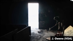 A man gives his surroundings a clean. Many return to the barracks after unsuccessful attempts to cross into Hungary.