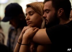 University of Nevada Las Vegas students Raymond Lloyd, right, and Karla Rodriguez take part in a vigil Monday, Oct. 2, 2017, in Las Vegas, Neveda.