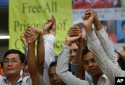 Members of the opposition Cambodia National Rescue Party raise joined hands for photographs at their party headquarters in Phnom Penh, May 27, 2016.