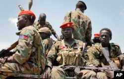 FILE - In this photo taken Oct. 16, 2016, a group of South Sudanese government soldiers sit on the back of a pickup truck before visiting the scene of a recent battle in Malakal, South Sudan.