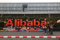 This photo taken on September 4, 2019 shows people taking photos at Chinese e-commerce giant Alibaba's headquarters in Hangzhou in China's eastern Zhejiang province.