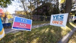 Lawn signs conflict with each other outside of a polling place on Nov. 2, 2021 in Minneapolis.