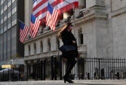 FILE - A person walks past the New York Stock Exchange (NYSE) at Wall Street on November 16, 2020 in New York City.