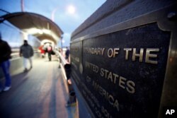 FILE PHOTO: People walk on the international border bridge Paso del Norte to cross to El Paso from Ciudad Juarez in El Paso, Texas, Dec. 29, 2016.