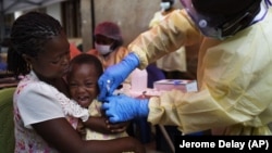 In this Saturday, July 13, 2019 photo, a child is vaccinated against Ebola in Beni, Congo.