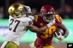지난 11월 로스엔젤레스에서 열린 NCAA 대학 미식축구 경기에서 서던캘리포니아의 마케세 스테프 선수(오른쪽)가 노트르담의 줄리안 러브 선수를 방어하고 있다.