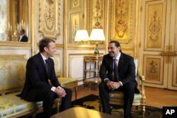 French President Emmanuel Macron, left, confers with Lebanon's Prime Minister Saad Hariri at the Elysee palace in Paris, Saturday, Nov. 18, 2017.