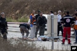 An Israeli forensic officer inspects the body of a Palestinian man at a checkpoint near the West Bank town of Nablus, Oct. 30, 2015.