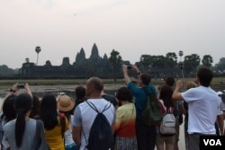 អ្នក​ទេសចរ​ថត​រូប​ថ្ងៃ​រះ​នៅប្រាសាទ​អង្គរវត្ត​កាល​ពី​ថ្ងៃ​សុក្រ​ទី​២០ ខែ​មីនា ឆ្នាំ​២០១៥។ (នៅ វណ្ណារិន/VOA)