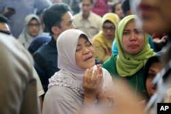 A relative of passengers prays as she and others wait for news on a Lion Air plane that crashed off Java Island at Depati Amir Airport in Pangkal Pinang, Indonesia Monday, Oct. 29, 2018.