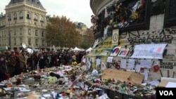 Ratusan orang memberikan penghormatan bagi para korban serangan di Paris, di depan Place de la Republique, Senin (16/11).