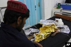 FILE - An injured boy receives treatment at a hospital after an airstrike in Helmand province, southern Afghanistan, Nov. 28, 2018. Civilians and Taliban fighters were killed in the strike as Afghan government forces battled insurgents.
