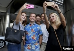 រូបឯកសារ៖ លោក Dmitry Medevedel នាយករដ្ឋ​មន្ត្រី​រុស្ស៊ី ថត​រូប​អនុស្សាវរីយ៍​ជាមួយ​នឹង​ភ្ញៀវ​ទេសចរ​ ខណៈពេល​ដែល​លោក​ធ្វើ​ដំណើរ​កម្សាន្ត​មួយ ក្នុង​អំឡុង​ដំណើរ​ទស្សនកិច្ច​នៅ​ទីក្រុង​កូឡាឡាំពួ ប្រទេស​ម៉ាឡេស៊ី ក្នុង​កិច្ច​ប្រជុំ​កំពូល​អាស៊ី​ខាង​កើត​កាល​ពី​ថ្ងៃទី២២ ខែ​វិច្ឆិកា ឆ្នាំ​២០១៥។ (Reuters/Dmitry Astakhov/Sputnik/Pool)